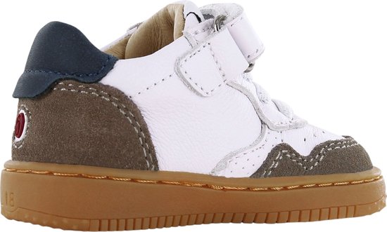 Zijkant van een witte leren babyschoen met bruine suède en donkerblauwe accenten.
