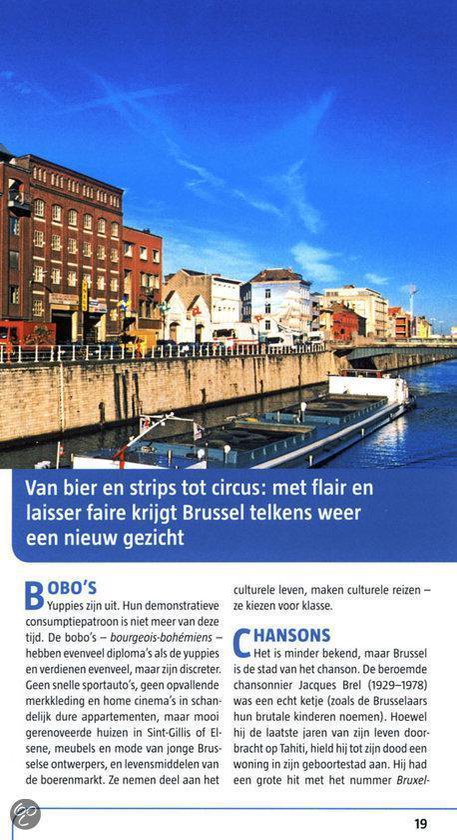 Een schip vaart op een breed kanaal omringd door bakstenen gebouwen onder een blauwe hemel.