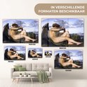 Verschillende maten van een glazen schilderij met een gevleugelde man die op rotsen zit.