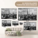 Verschillende formaten glasafbeeldingen van Antwerpen, waaronder 180x120, 120x80, 100x150, 90x60, 60x40 en 30x20, boven een bank.