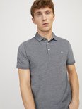 Man met kort, golvend blond haar draagt een grijs gemêleerd poloshirt met korte mouwen en Jack & Jones logo.