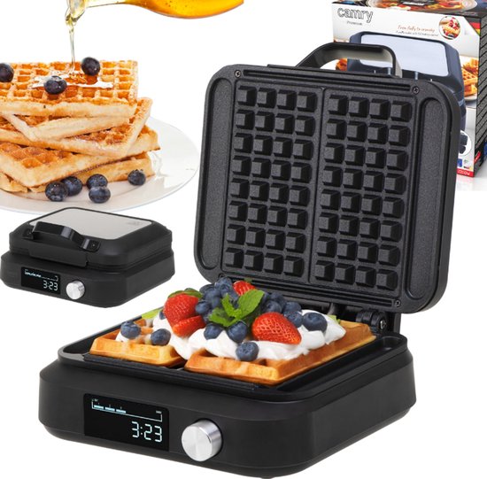 Zwarte wafelijzer met open deksel, bereidt twee wafels voor, met stapel wafels en fruit ernaast.