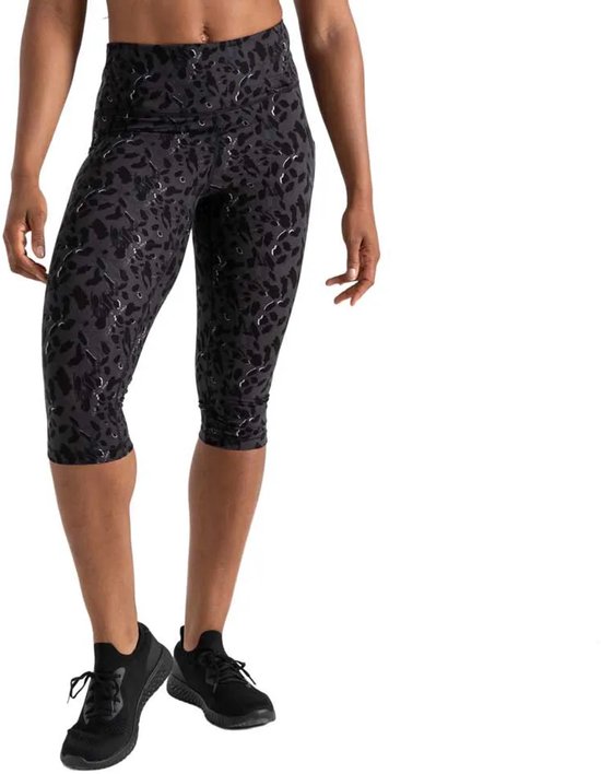 Vrouw in zwarte 3/4 legging met luipaardprint, witte accenten en zwarte sneakers.