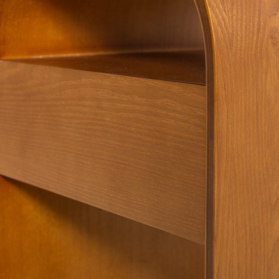 Close-up van het houten nachtkastje met zicht op de plank en de gebogen rand.