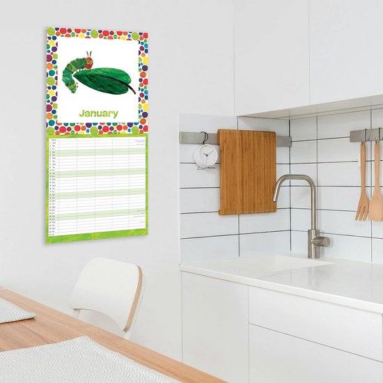 De Hongerige Rups 2025 Familiekalender in januari. De kalender hangt boven een tafel en een keuken aanrecht.