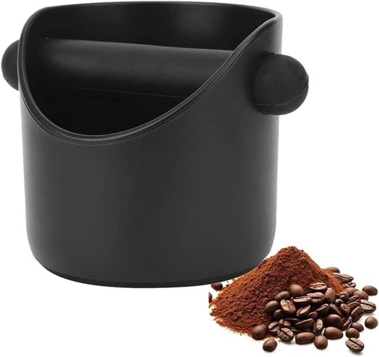 Zwarte koffiedikbak met een hoop gemalen koffie en koffiebonen ernaast.