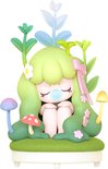Boselffiguur met lichtgroen haar, zittend tussen planten en paddenstoelen.