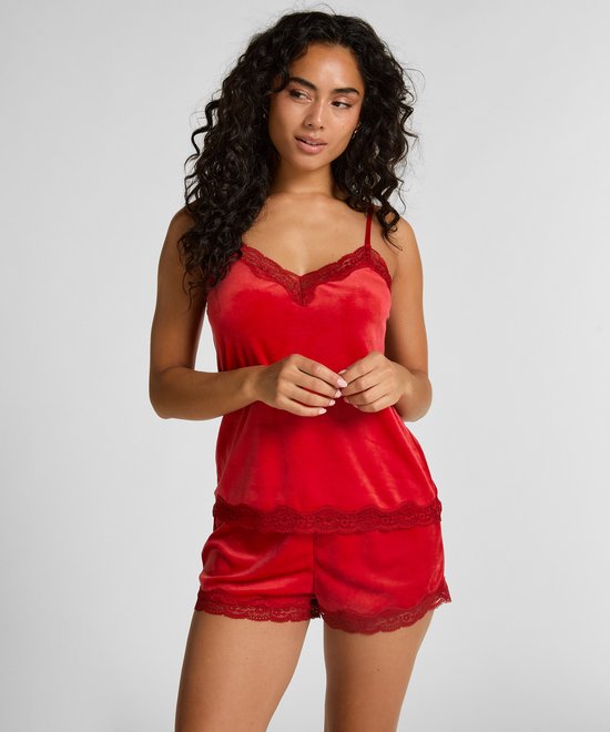 Model in rode cami top met kanten V-hals en bijpassende short.