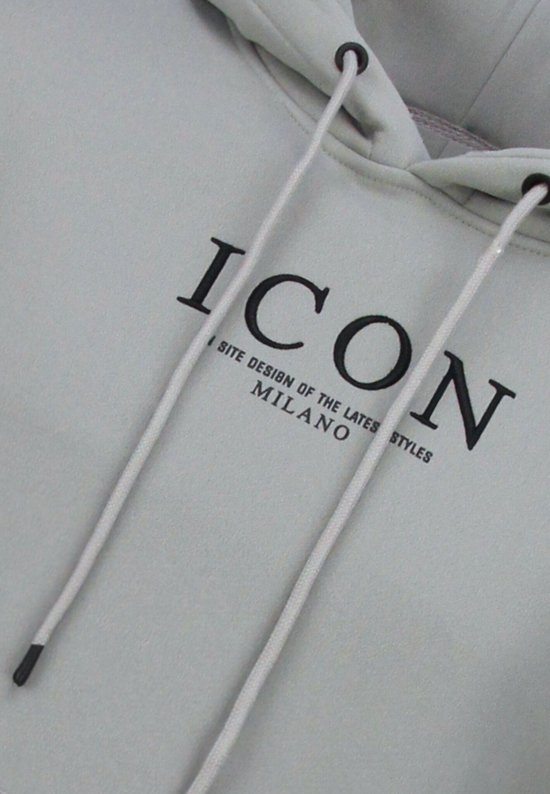 Detail van een lichtgrijze hoodie met zwarte "ICON MILANO" tekst en touwtjes.