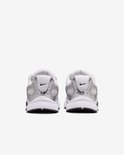 Achterkant van witte en zilverkleurige Nike sneakers met zwarte Swoosh op de hiel.