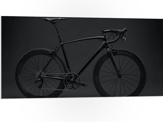WallClassics - PVC Schuimplaat- Zwarte Fiets tegen Donkere Achtergrond - 100x50 cm Foto op PVC Schuimplaat