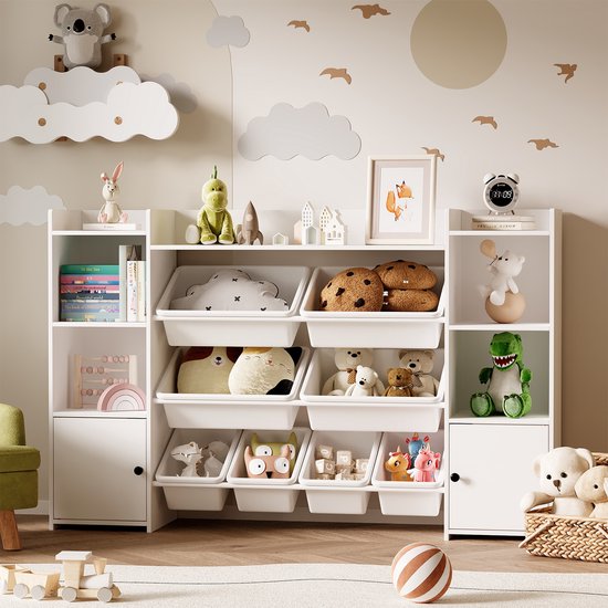 Witte opbergkast vol met speelgoed, knuffels en boeken, in een kinderkamer met muurdecoratie.