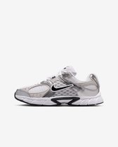 Zij-aanzicht van witte en zilverkleurige Nike sneakers met zwarte Nike swoosh.