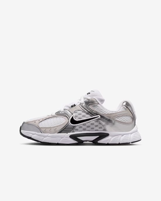 Zij-aanzicht van witte en zilverkleurige Nike sneakers met zwarte Nike swoosh.