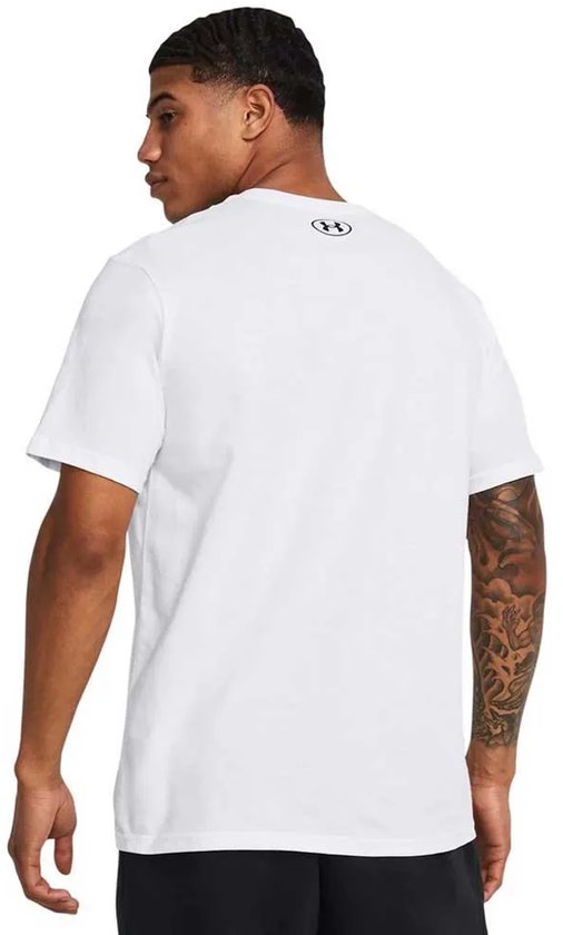 Man met getatoeëerde armen in een wit Under Armour T-shirt, zichtbaar van achteren.