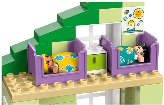 Deux figurines Duplo dorment dans des lits violets avec des couvertures jaunes et bleues.