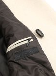 Binnenkant van crèmekleurige wollen jas met bruine voering, rits en label 'MADE IN EUROPE'.