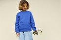 Jongen in blauwe trui met LEGO Technic John Deere 1470H bosbouwmachine in zijn hand.