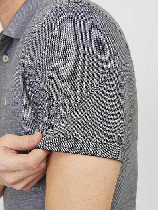 Close-up van de mouw van een grijs gemêleerd poloshirt met korte mouwen en een gestreept boordje.