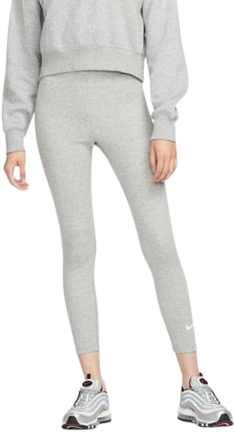 Een model draagt een lichtgrijze Nike legging en bijpassende trui met sneakers.