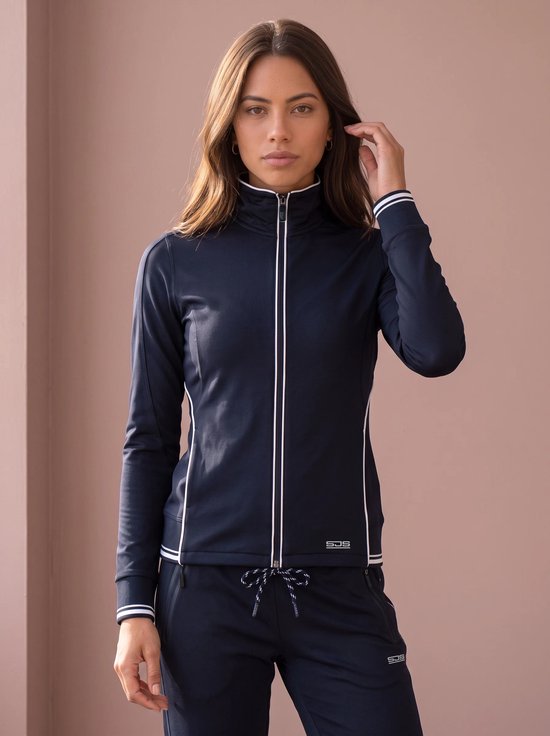 Model in een donkerblauw trainingsjack met witte biezen en bijpassende broek met trekkoord.
