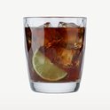 Un verre de boisson brune avec glaçons et une tranche de citron vert.