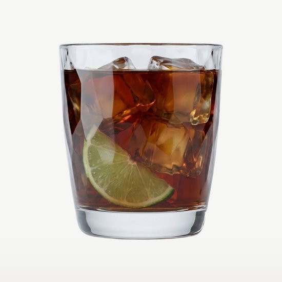 Un verre de boisson brune avec glaçons et une tranche de citron vert.