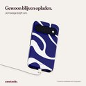 Telefoon met blauw-witte golven-hoes aan een oplaadkabel.