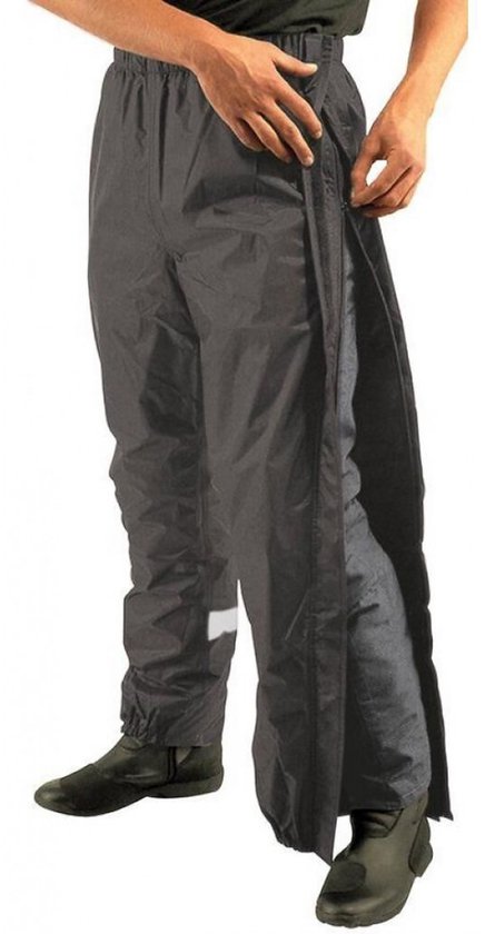 Zwarte Mac in a Sac regenbroek met volledige ritssluiting aan de zijkant, gedragen over een broek.