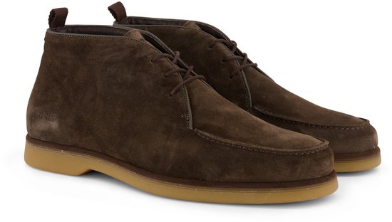 Paar bruine suède chukka boots met vetersluiting en gummi zool.