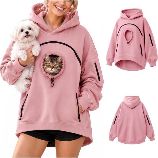 Roze hoodie voor huisdieren met een kat in de opening op de borst, gedragen door een model met een kleine witte hond.