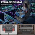 Vrouw zit in een extra brede grijze Huracan-gamestoel terwijl ze met een handheld console speelt.