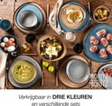 Een gedekte tafel met diverse blauwe, grijze en bruine borden, mokken en schalen met eten.