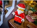 LEGO Santa Minifiguur in een feestelijke kerstsfeer, op een houten tafel met cadeaus.
