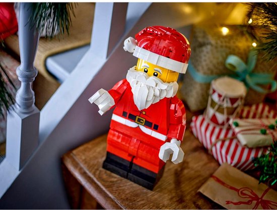 LEGO Santa Minifiguur in een feestelijke kerstsfeer, op een houten tafel met cadeaus.