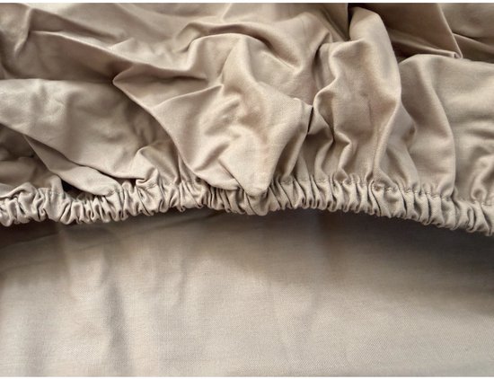 Detailopname van de elastische zoom van een taupekleurig perkal-katoenen hoeslaken.