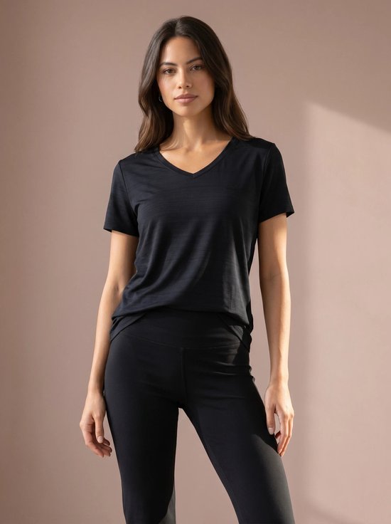 Model in een zwarte V-hals t-shirt met korte mouwen en zwarte legging.