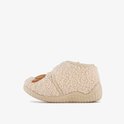 Zijzicht van beige, teddy slof met bruine croissant applicatie en klittenbandsluiting.