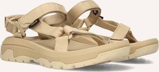 Detail van lichtbruine Teva sandalen met klittenband, met zichtbare Teva-logo's.