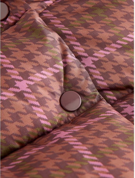 Detail van bruine jas met roze en groene ruit en bruine knopen.