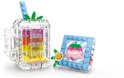Verre transparent avec couches colorées, paille et feuille verte, à côté d'un bloc bleu clair avec imprimé fraise et texte 'Sweet'.