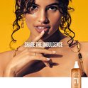 Een model met krullend haar en gouden oorbellen met de tekst 'SHARE THE INDULGENCE'.