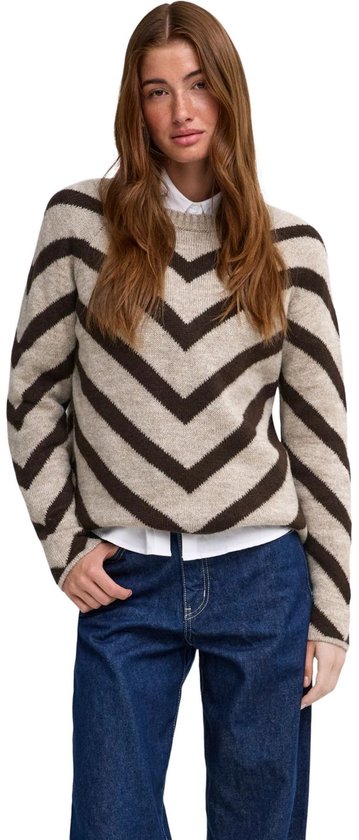 Lichtbruine trui met donkerbruine chevronprint, gedragen door een model met een witte blouse en jeans.
