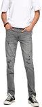 Grijze skinny jeans met scheuren op de knieën, gedragen door een man met een wit T-shirt.