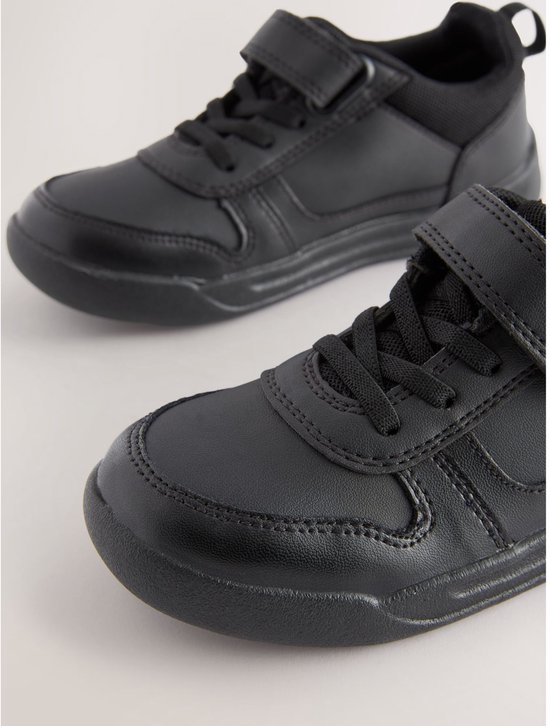 Twee zwarte leren sneakers met klittenbandsluiting en elastische veters, op een witte achtergrond.