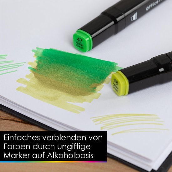 Twee zwarte stiften met alcoholbasis, één met groene "Grass Green 47" dop, op papier met groene en gele vegen.