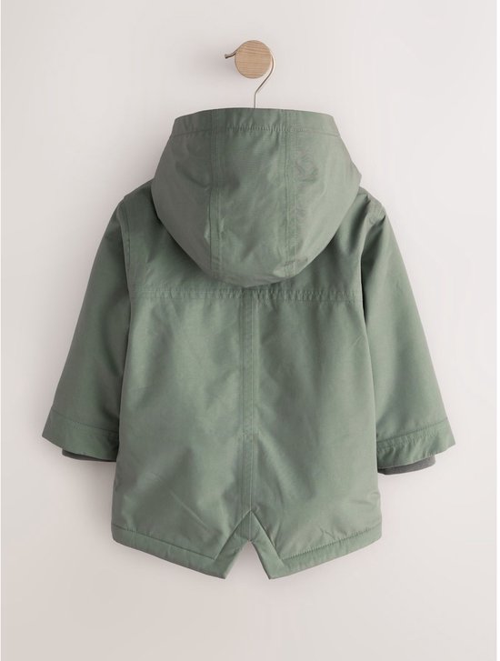 Achterzijde van een groene parka met capuchon, hangend aan een kleerhanger tegen een lichte achtergrond.