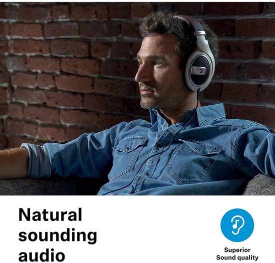 Man met blauw denim overhemd draagt een crème Sennheiser koptelefoon met bruine accenten.
