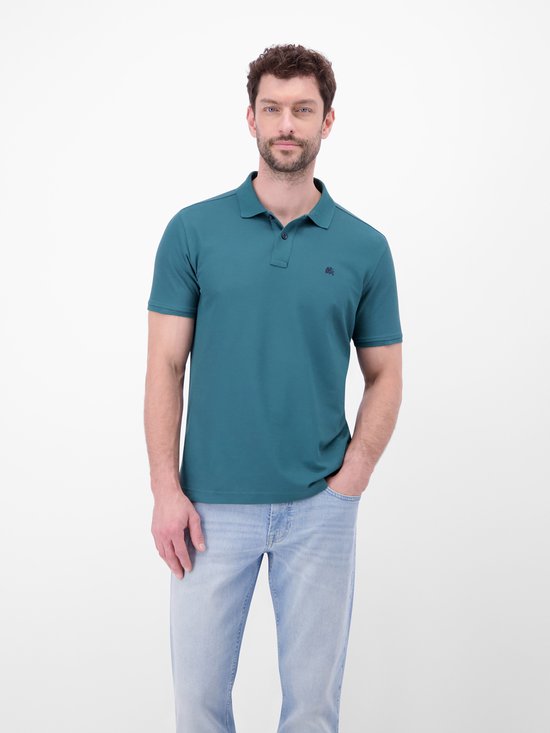 Blauwe polo met donkerblauwe kraag en knopen, model met hand in zak