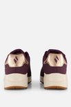Achterkant van paarse Skechers sneakers met beige zool en gouden hieldetails.